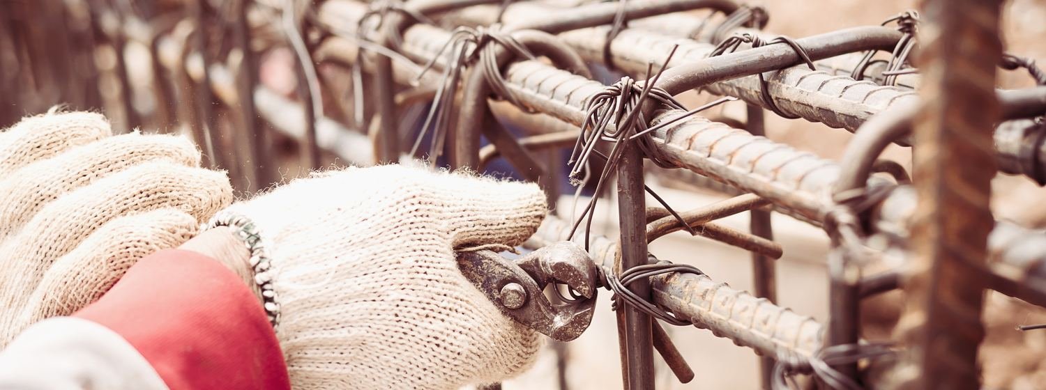 Worker tying rebar reinforcement with wire