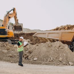 Estimator reviewing plans on a construction site
